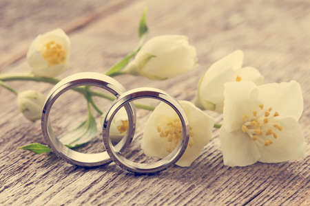 Wedding rings with wild flower on wooden backgroundの写真素材