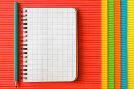 Blank  notebook with pencil on colored corrugated paperの写真素材