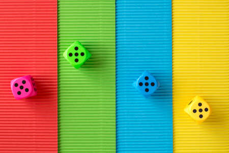 Four dices on colored corrugated paper backgroundの写真素材