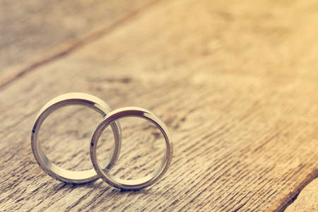 Soft pastel image with wedding rings on wooden backgroundの写真素材