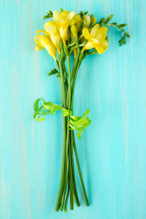 Bouquet of freesia flowers lying on the wooden backgroundの写真素材