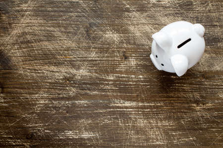 Piggy bank on the scratched wooden background, top viewの写真素材