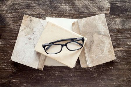 Books and reading glasses on the wooden background.Top view.の写真素材