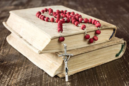 The rosary and old books on wooden backgroundの写真素材