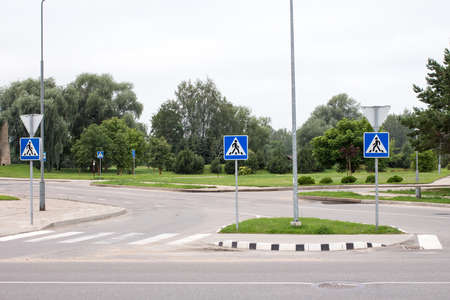 Empty city street and zebra with pedestrian signs
