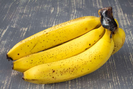 Bunch of yellow bananas on wooden surfaceの写真素材