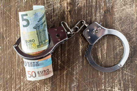 Money and handcuffs. Concept for corruption, fraud, money laundryの写真素材