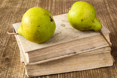 Stack of old books with two green pearsの写真素材