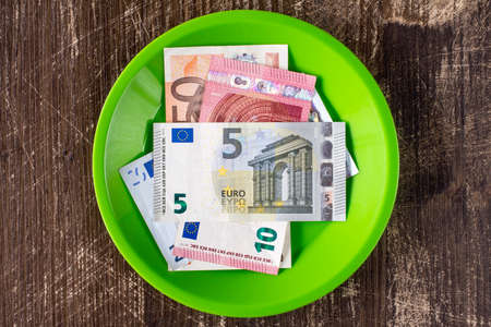 Green plate with Euro notes. High price of food concept.の写真素材