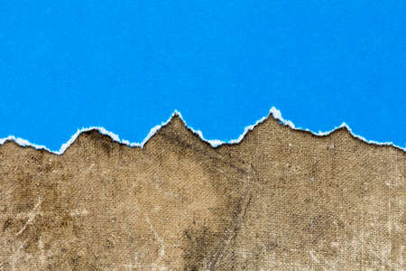 Torn blue paper on dirty canvas backgroundの写真素材