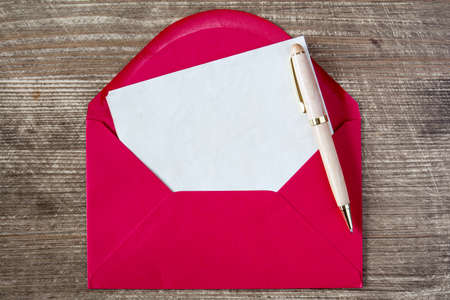 Blank paper, envelope and pen on wooden backgroundの写真素材