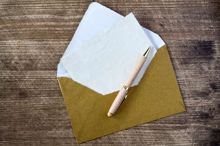 Envelope,blank letter and pen on wooden background