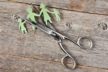 Scissors cutting paper cut of family. Broken family or divorce concept.の写真素材
