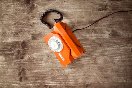 Old orange retro phone with rotary dial.の写真素材