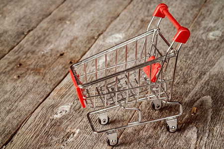 Empty shopping trolley on the wooden background.の写真素材
