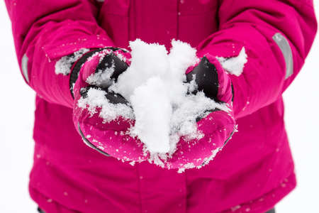 Image of a small child who holds in his hands a lump of snow.の写真素材