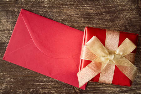 Gift box and red envelope on wood backgroundの写真素材