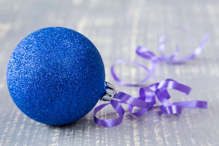 Blue bauble with ribbon on wooden backgroundの写真素材