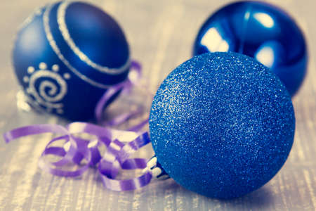 Blue baubles with ribbon on wooden backgroundの写真素材
