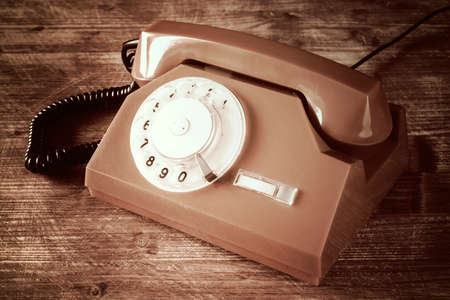 Old phone on a wooden table with dark background