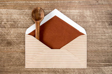 Mail envelope with a small wooden spoon の写真素材