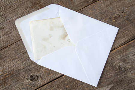   White envelope with blank card on wooden backgroundの写真素材