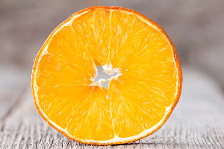 Cross section of orange fruit,close up on wooden background