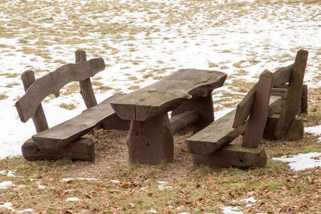 Wooden picnic table with benches in the winter parkの写真素材