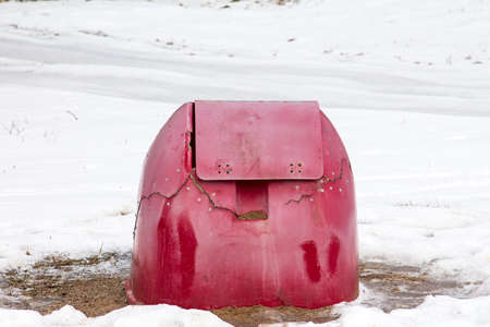 Broken red container for grit and salt in winter timeの写真素材