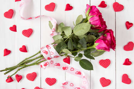 Bouquet of red roses with ribbon and many decorative heartsの写真素材