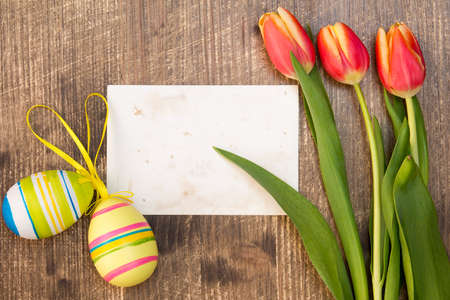 Easter eggs,spring tulips and blank card for copy-spaceの写真素材