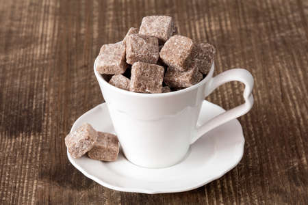 White cup full of brown cane sugarの写真素材