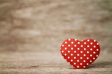 Red polka dot heart on wooden backgroundの写真素材