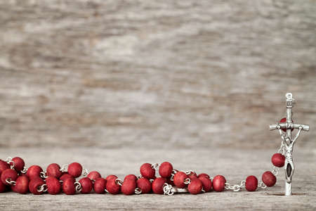 Close-up view of catholic rosary on wooden texture backgroundの写真素材