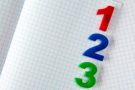 Color plastic numbers on paper exercise book in a cellの写真素材