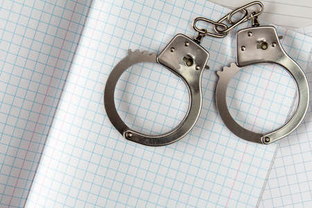 Concept for hard study, blank exercise book and handcuffsの写真素材