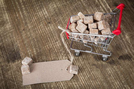 Cane sugar cubes in shopping cart with blank paper tagの写真素材