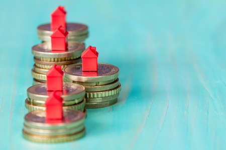 Real estate mortgage concept with small house models on coins rowの写真素材