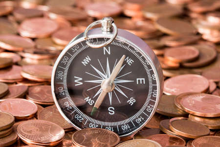 Pile of euro cent coins with a compass.Concept for financial direction