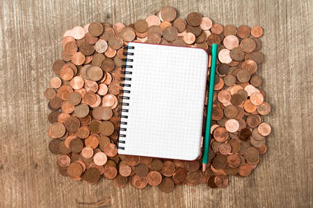 Blank notebook on the heap of euro cent coins of different denominationsの写真素材