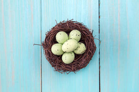 Nest with painted eggs on wooden background. Top view.の写真素材