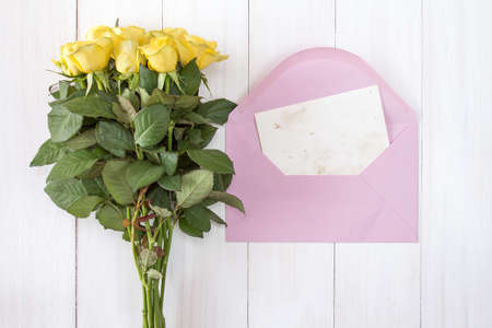 Yellow roses and love letter or note card with pink envelopeの写真素材