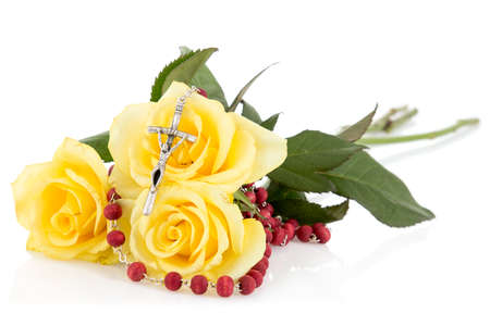 Silver crucifix and yellow roses,isolated on white backgroundの写真素材