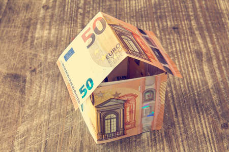 House made of Euro banknotes on a wooden backgroundの写真素材