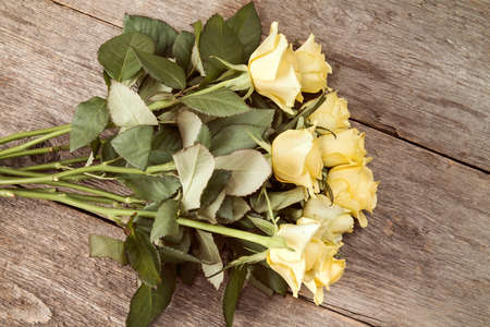Bouquet of yellow roses on wooden background, top viewの写真素材