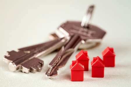 Red miniature houses and bunch of keys. Real estate concept.の写真素材