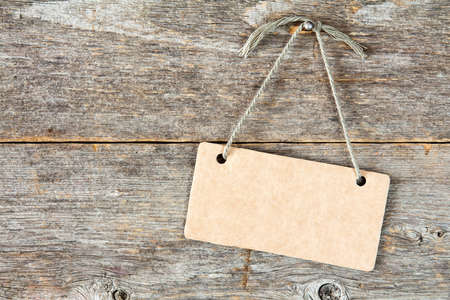 Paper sign board on the old wooden backgroundの写真素材