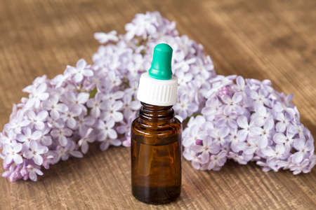 Essential aroma oil with lilac on wooden backgroundの写真素材