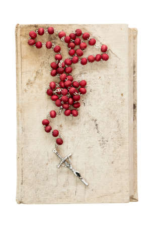 Catholic rosary on old book,isolated on white backgroundの写真素材