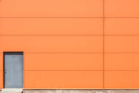 Modern orange building wall with metal doorsの写真素材
